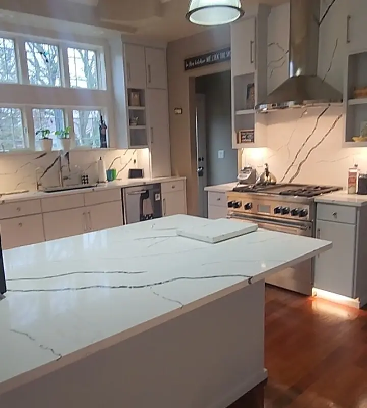 White quartz island and matching full-height backsplash installed by Counterstone